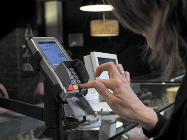 Alıcı kartı satınalmalarda öder. Bayan banka kartını kullanarak satın alır. Kredi kartı ile satın.