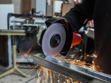 Daire testere ile kesme kıvılcım. Elektrik değirmeni aracıyla fabrikasında, çelik yapı üzerinde çalışan bir erkeğin kıvılcım uçan. 