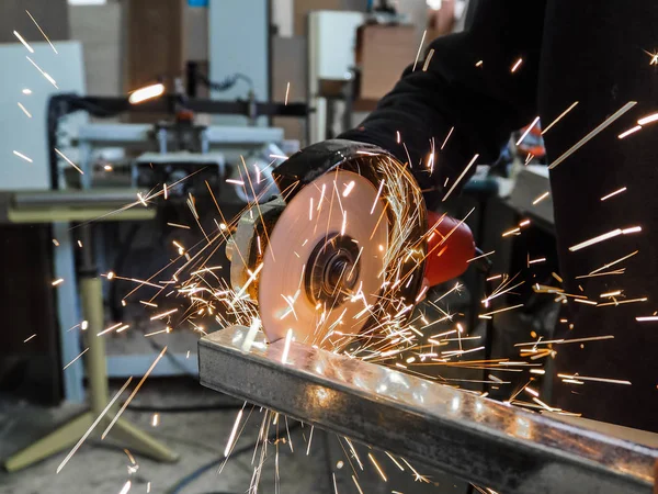 Daire testere ile kesme kıvılcım. Elektrik değirmeni aracıyla fabrikasında, çelik yapı üzerinde çalışan bir erkeğin kıvılcım uçan. 