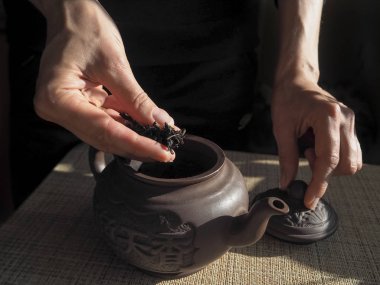 Bayan uykuya düşen bir kil demlik çay. Kil çaydanlık. Çay töreni. Kadın elinde çay.