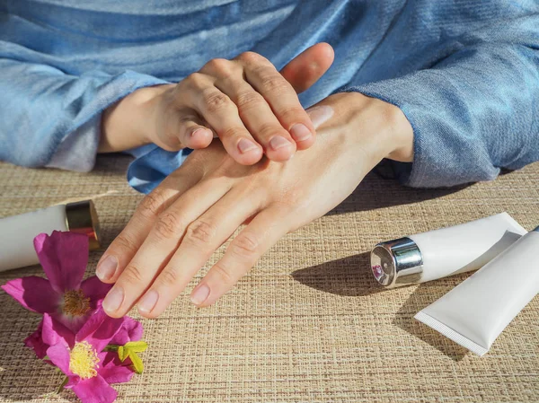 Kadın elleri cildine nemlendirici krem sürüyor.. 