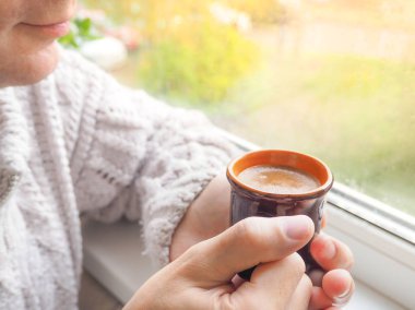 Eller erkekler pencerede kahve içme. Bir fincan espresso elinde.