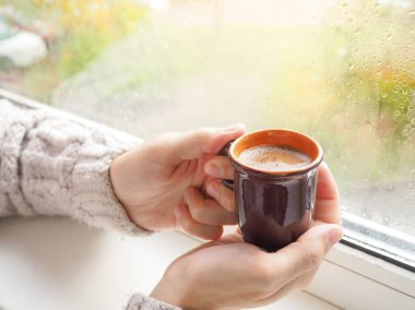 Eller erkekler pencerede kahve içme. Bir fincan espresso elinde.