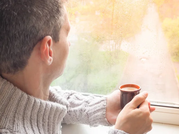 Pencere kenarında kahve içen adam..