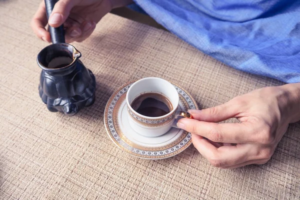 Hand met een kopje koffie. Zwarte koffie gegoten van de Turken. — Stockfoto