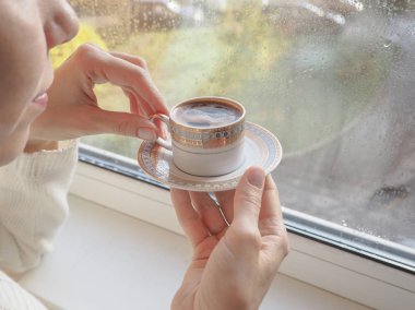 Pencerenin yanında kahve içme kadın.