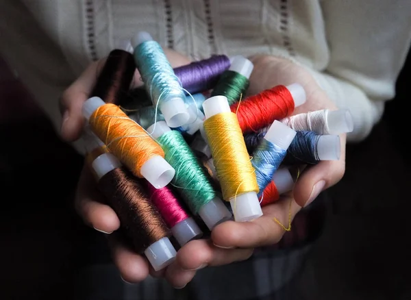 Silk colorful threads for needlework in her hands. — Stock Photo, Image