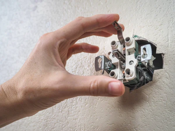 Electrician repair the outlet on the wall.