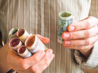 Elinde Arapça dirhem.