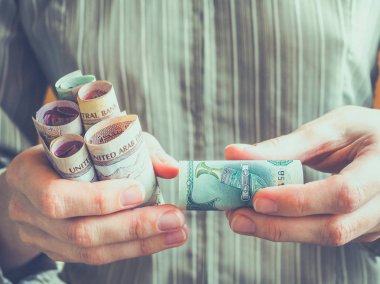 Elinde Arapça dirhem.