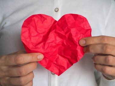 Bağışlanan kalp. Büyük ve küçük kırmızı kalp elinde.