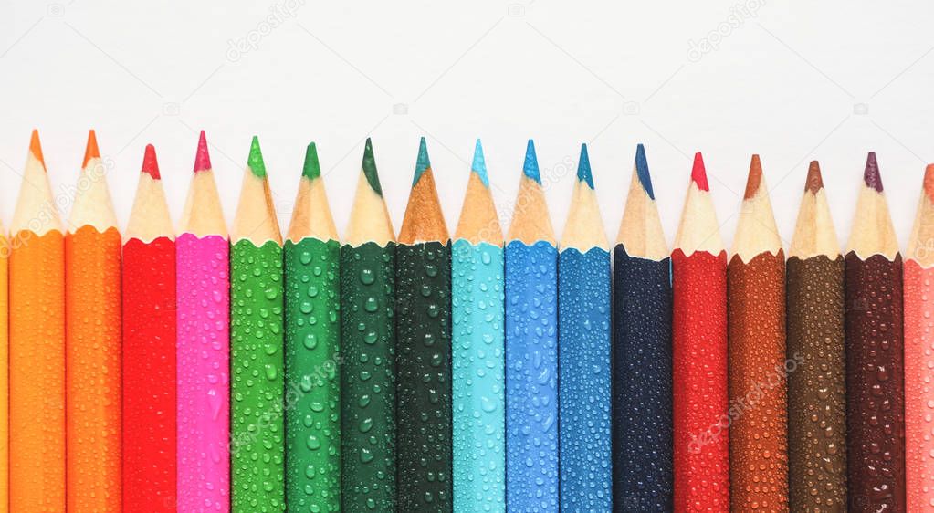 Colored pencils. Abstract colored background. Colored pencils in hand.