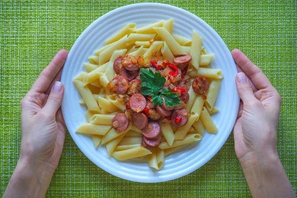 Fried sausages with vegetables and pasta. Simple delicious rustic dish. The view from the top.