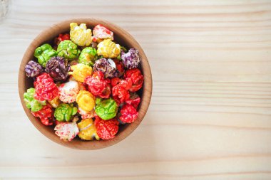 Ahşap arka plan içinde renkli patlamış mısır. Üstten Görünüm. 