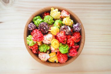 Ahşap arka plan içinde renkli patlamış mısır. Üstten Görünüm. 