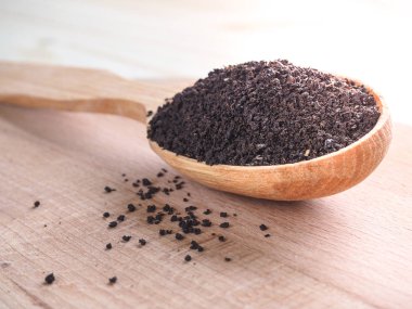 Bir kaşık ile ahşap bir çanak içinde gevşek çay.