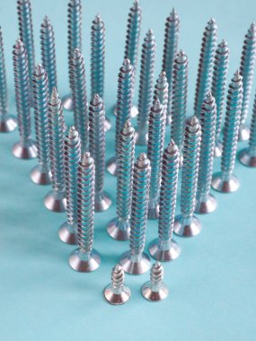 Mavi zemin üzerine beyaz inşaat vidalar.