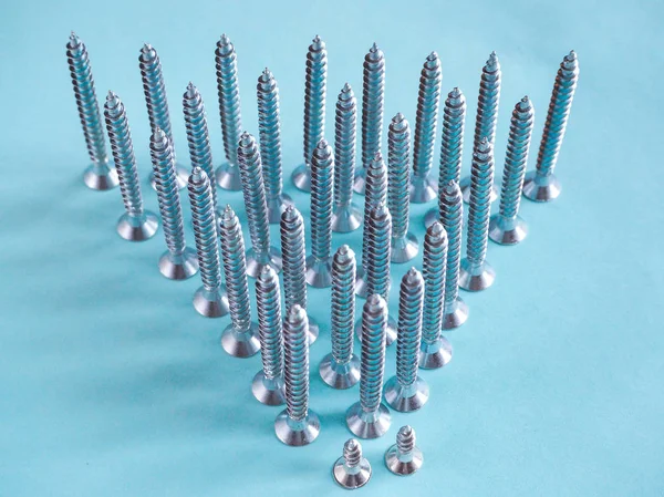 Mavi zemin üzerine beyaz inşaat vidalar.