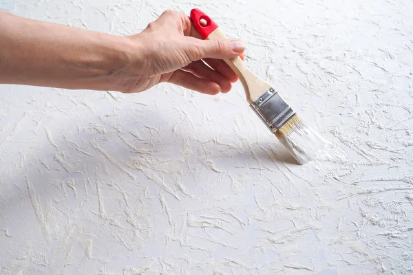 Decorar la superficie de la pared con esmalte usando un pincel . — Foto de Stock
