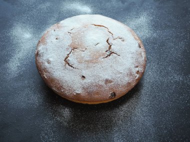 Büyük pasta kurabiye ile fındık ve siyah arka plan üzerine kuru üzüm.