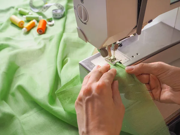 Seamstress works on a sewing machine. Stages of the production cycle on a sewing machine. — Stock Photo, Image