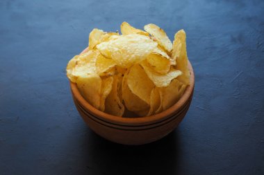 Koyu mavi zemin üzerine patates cipsi.