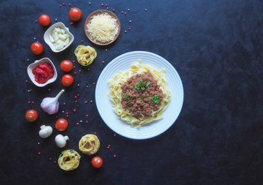 Siyah bir zemin üzerine Beşamel soslu makarna.
