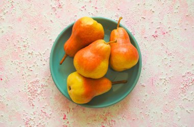 Pembe bir arka plan üzerinde olgun sarı armut. Üstten Görünüm.