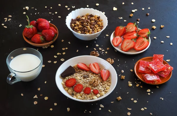 Muesli con fresas sobre una mesa negra. Desayuno tradicional europeo con muesli . — Foto de Stock