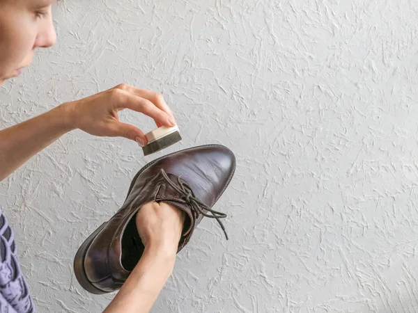 Una mujer está limpiando sus zapatos . — Foto de Stock