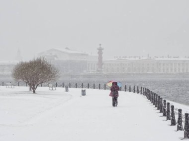 Kar altında şemsiyesi olan kadın. 