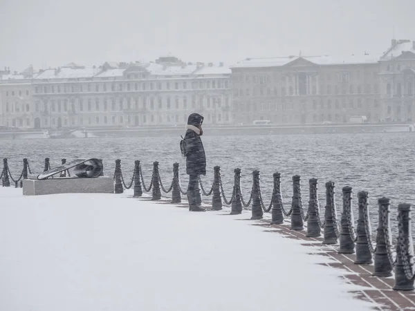 Ein einsames Mädchen unter starkem Schnee in der Winterstadt — Stockfoto
