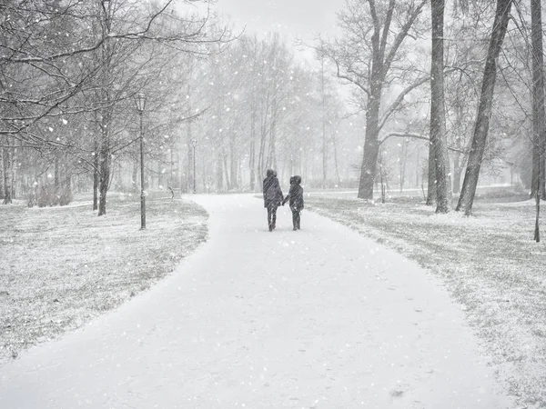 Две юные подруги, гуляющие в снежном зимнем парке . — стоковое фото