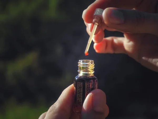 Una gota de aceite de lodo. Perfume de oud attar árabe o fragancias de aceite de madera de agar en mini botellas . — Foto de Stock