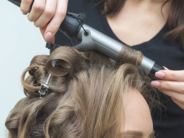 Saç şekillendirme işlemi. Bir akşam saç stili yaratıyorum. Modaya uygun kadın saç stili..