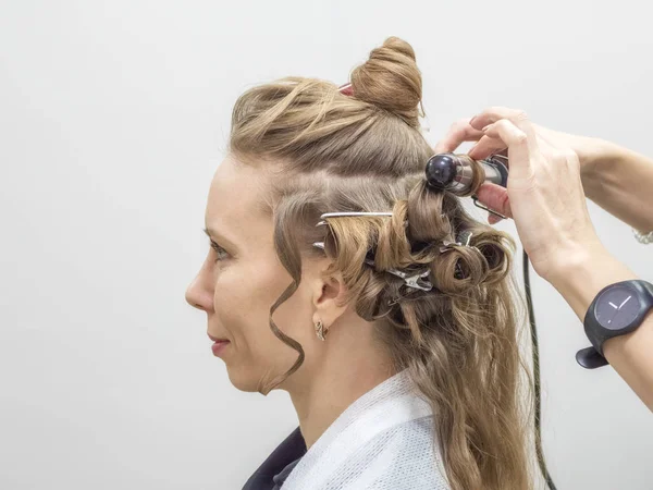 Proceso de peinado. Creando un peinado nocturno. Peinado femenino con estilo de moda . — Foto de Stock