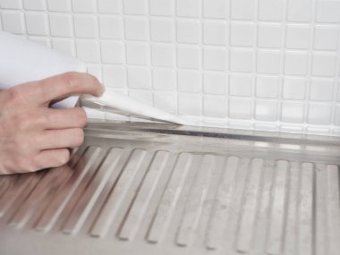 Mutfağa lavabo takmak için silikon yapıştırıcı kullanıyor. Evde mobilya kurulumu sağlayan profesyonel tamirci servisi
