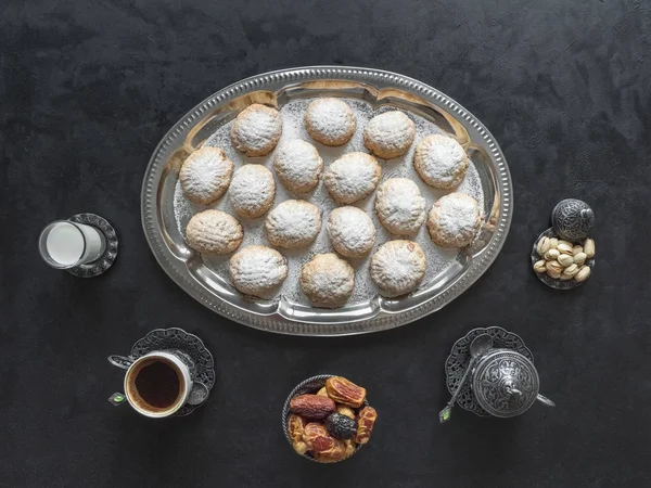 Τα γιορτινά γλυκά του Ραμαζανιού σερβίρονται με τσάι στο μαύρο τραπέζι. Αιγυπτιακά cookies "Kahk El Eid" - cookies του El Fitr Islamic Feast. Άνω όψη — Φωτογραφία Αρχείου