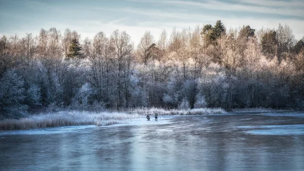 Belo dia de inverno com pesca no gelo. Panorama de uma paisagem de inverno com um lago congelado e árvores brancas na geada — Fotografia de Stock