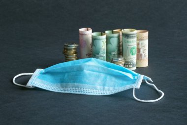 Tıbbi maske ve para. Salgın ve konseptin ekonomik krizi