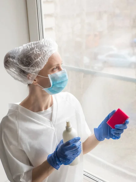 Desinfección por Coronavirus. Gente haciendo desinfección en ventanas. Doctor en guantes de goma desinfecta ventanas con desinfectante y esponjas — Foto de Stock
