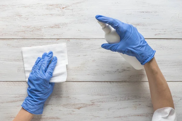 Limpieza de superficies pulverización antibacteriana desinfectante botella de aerosol desinfectante contra COVID-19 difusión con guantes azules médicos — Foto de Stock