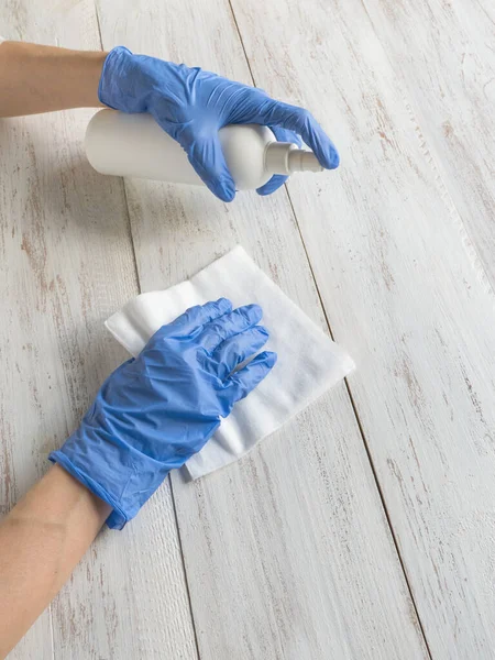 Limpieza de superficies pulverización antibacteriana desinfectante botella de aerosol desinfectante contra COVID-19 difusión con guantes azules médicos — Foto de Stock