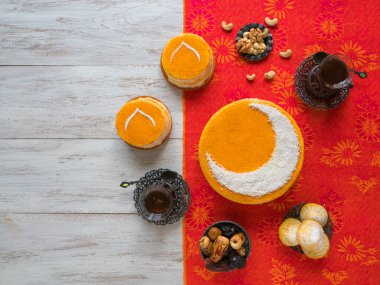 Ev yapımı, Hilal aylı, çay fincanı ve hurma ile servis edilen altın pasta. Ramazan arka planı
