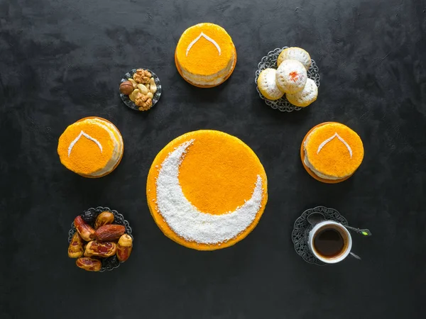 Festive food Ramadan background. Delicious homemade golden cake with a Crescent moon, served with black coffee and dates. Top view