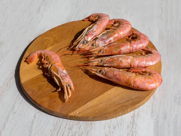 Camarones gigantes frescos cocinados en una tabla de cortar de madera. Vista superior —  Fotos de Stock