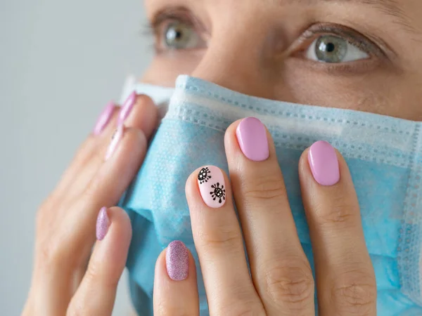 Creative manicure with painted coronavirus on the nails, soft focus, close up