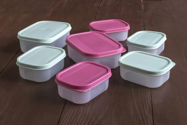 Plastic containers voor het vervoer en de opslag van levensmiddelen op een houten tafel — Stockfoto