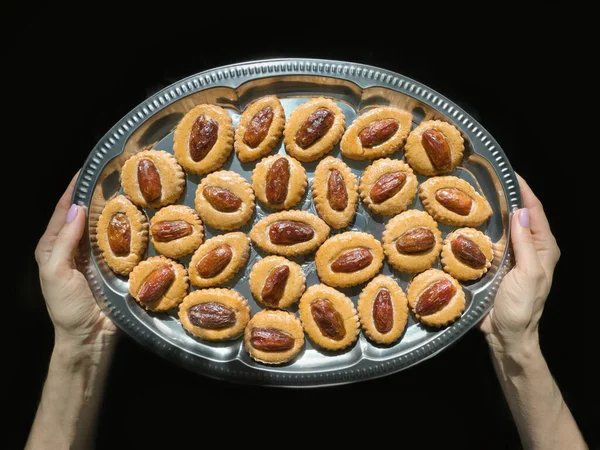 Homemade Eid Dates sweets on a tray in hands.