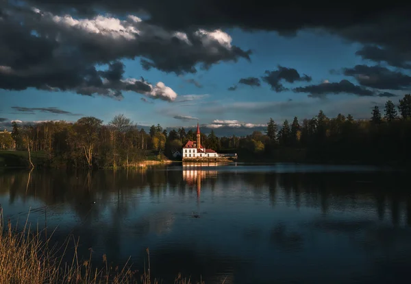 Bela paisagem dramática com um castelo junto ao lago e nuvens escuras de tempestade . — Fotografia de Stock